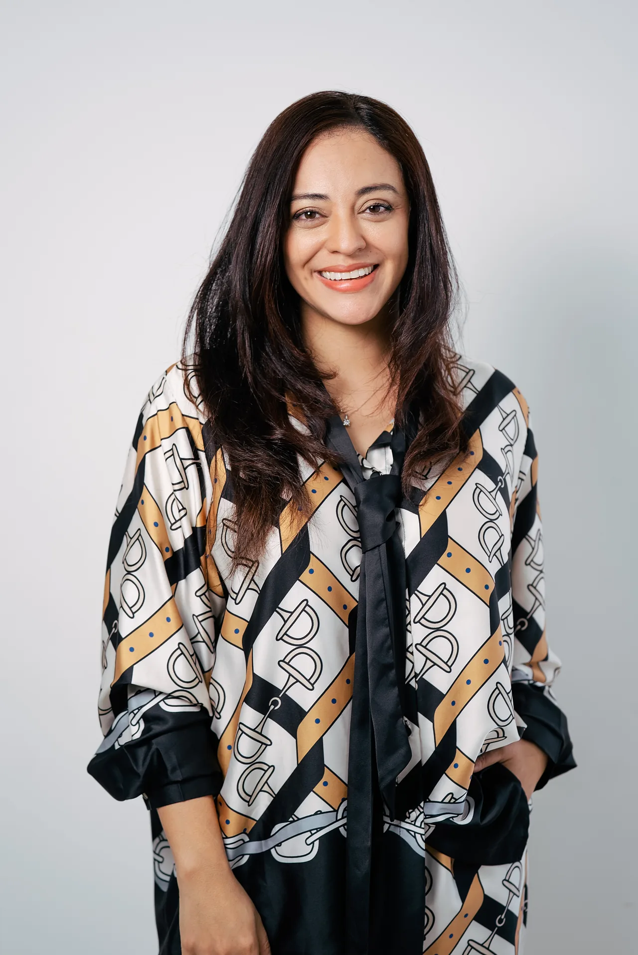 La Dra. Kim Rubattino, directora de la clínica, sonriente, con blusa estampada negra, blanca y dorada.